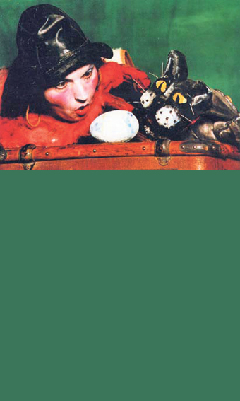 Eine verkleidete Person und ein Katzen-Figur schauen gemeinsam auf ein Ei.