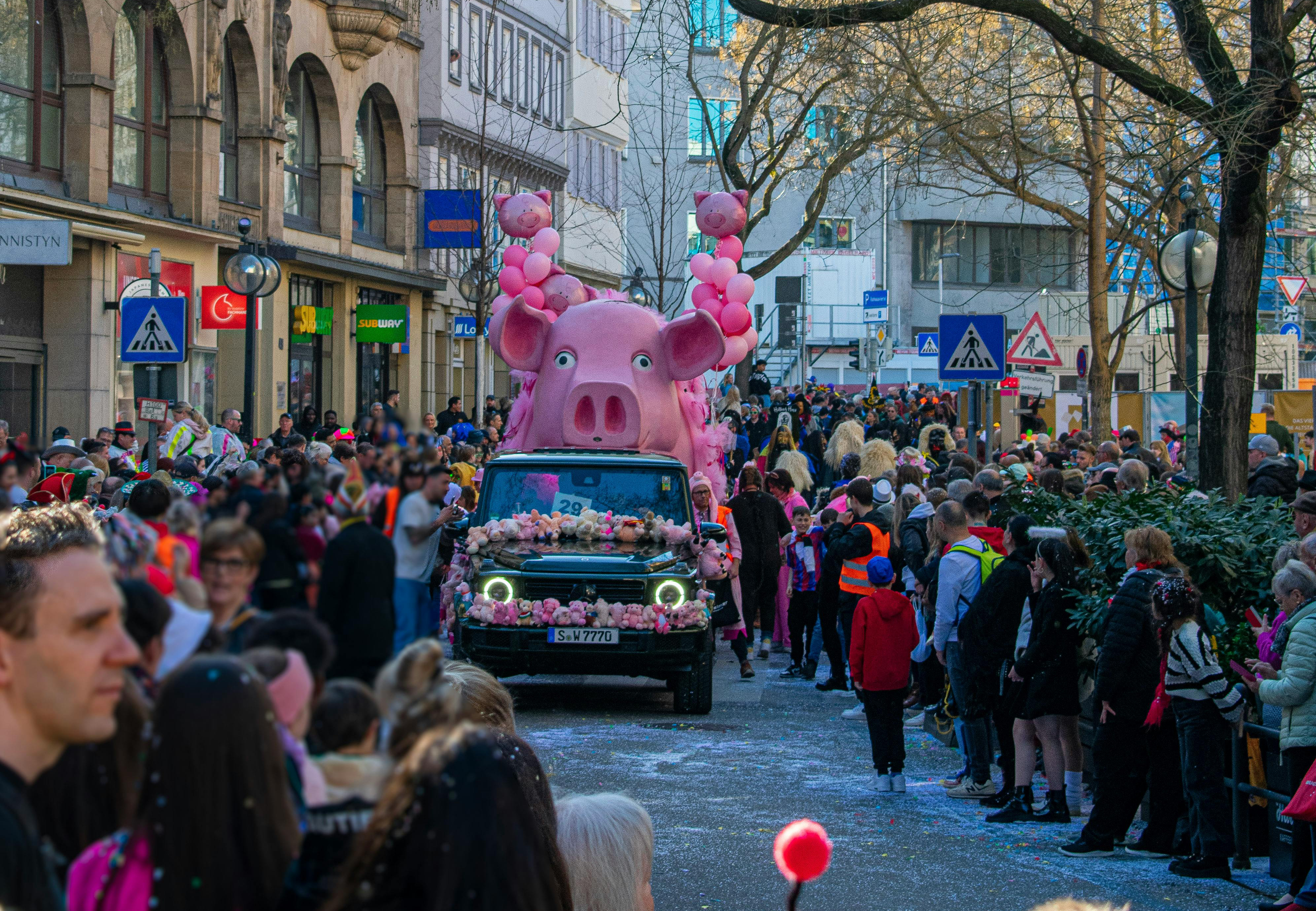 Ein Auto mit Pappmaché-Verzierung fährt beim Faschingsumzug durch die Eberhardstr. in Stuttgart