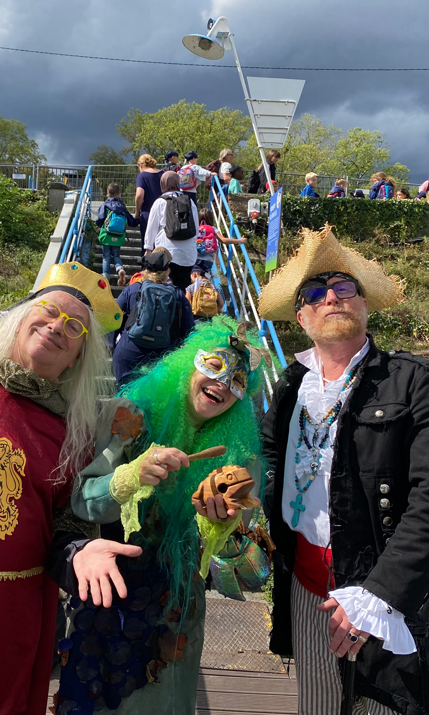 Zugangsstelle zu den Schiffen des Neckar Käptn. Drei Erwachsene in Verkleidung im Vordergrund.