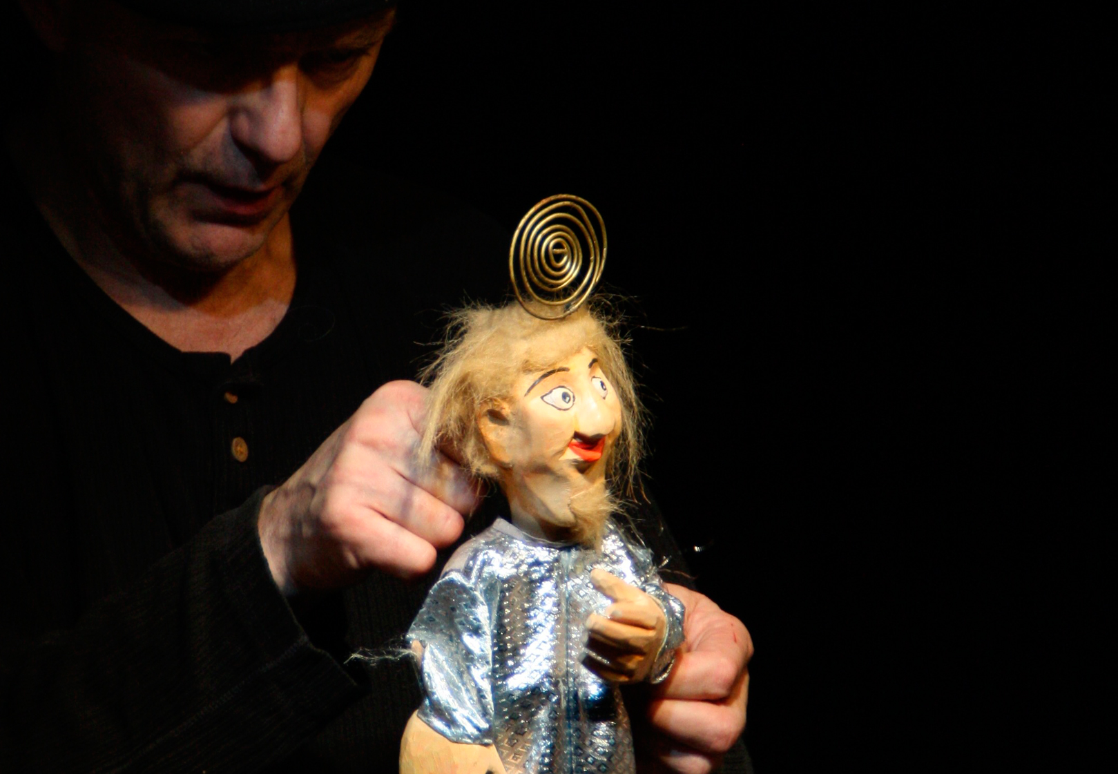 Ein Mann hält eine Handpuppe in den Händen.