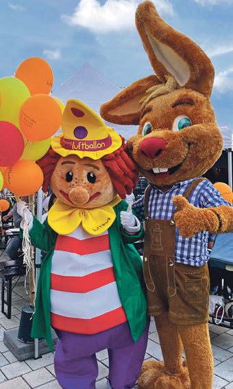 Die Maskottchen Luftikus und Wasenhasi stehen Arm in Arm auf dem Frühlingsfest.