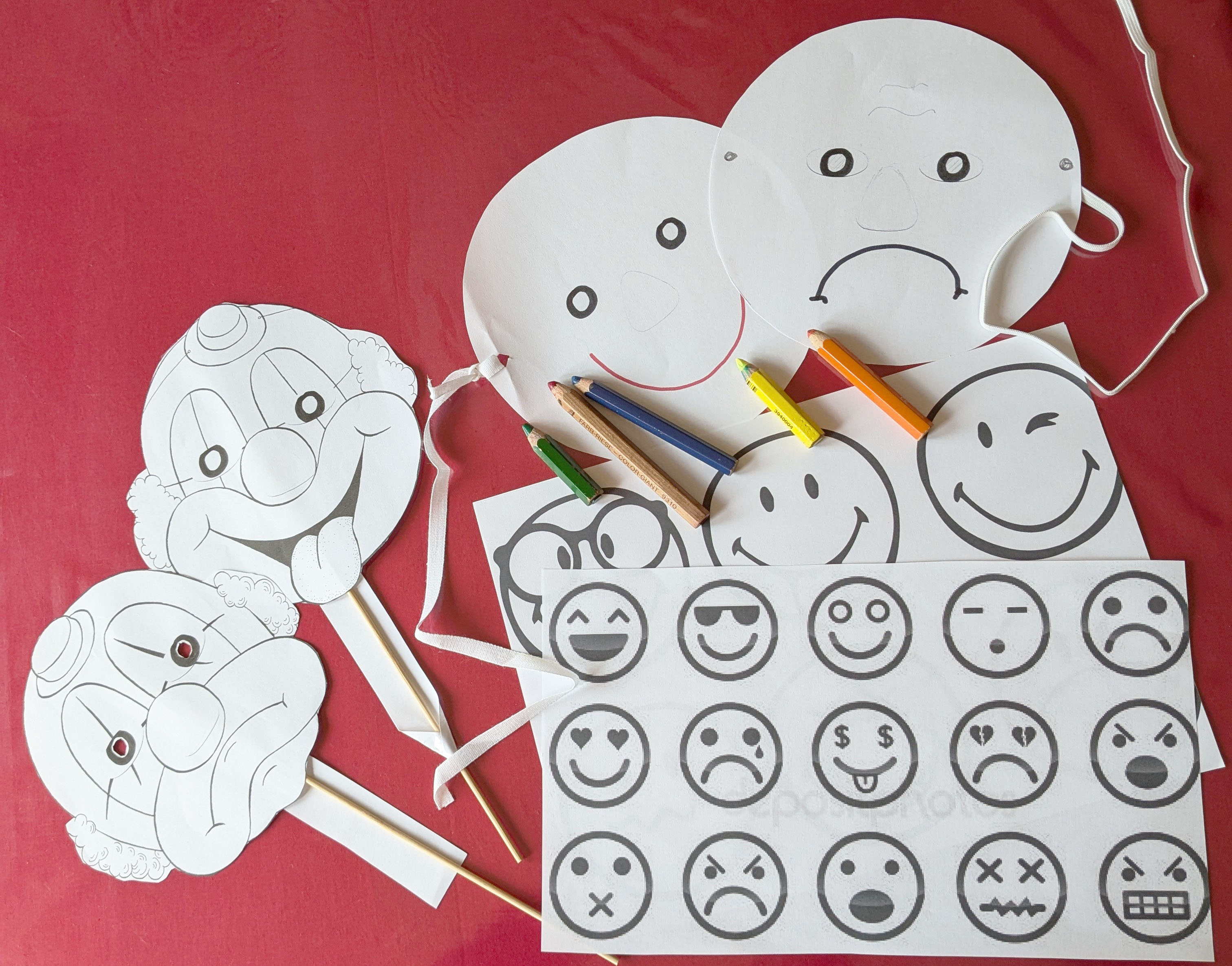 Gebastelte Masken aus Papier. An den aufgemalten Bildern kann man Gefühle ablesen.