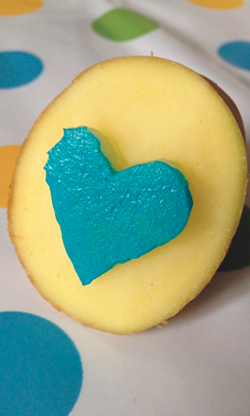 Aus einer Kartoffel wurde ein Stempel geschnitzt und mit blauer Farbe angemalt.