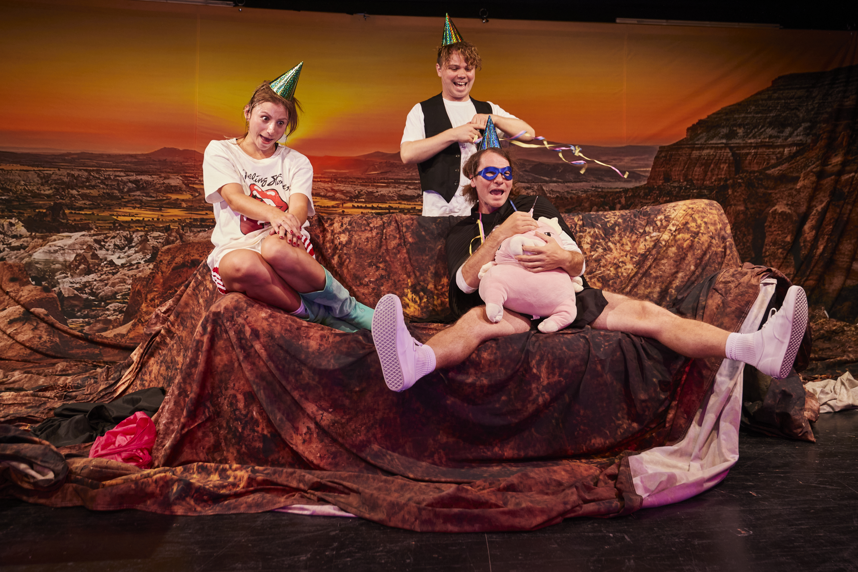 Zwei Männer tragen eine Frau über die Bühne