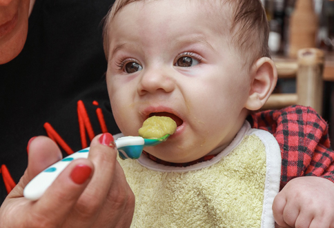 Baby wird mit Brei gefüttert