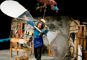 Frau steht in einer Werkstatt und trägt eine Art von Flügeln an den Armen.