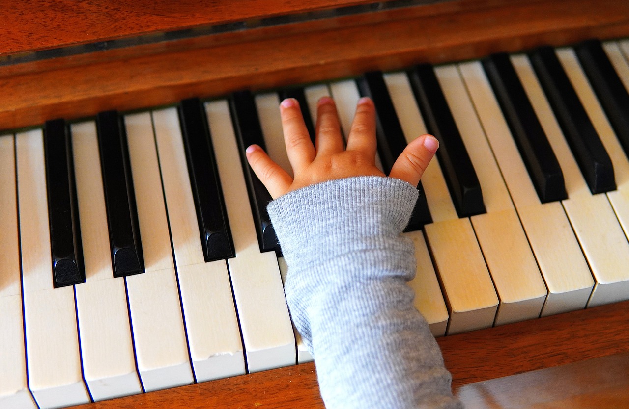 Eine Kinderhand spielt Klavier.