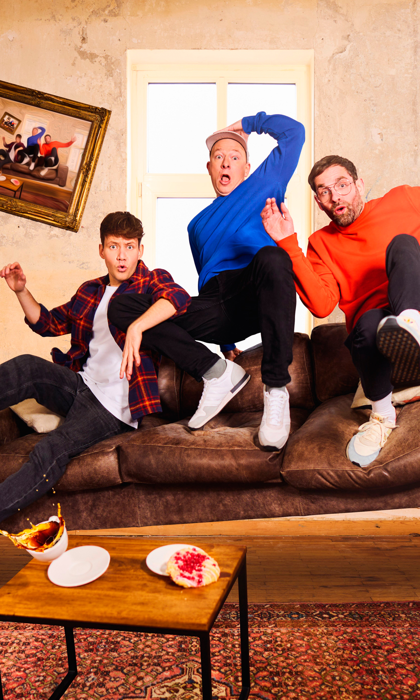 Drei Männer sitzten auf einem Sofa