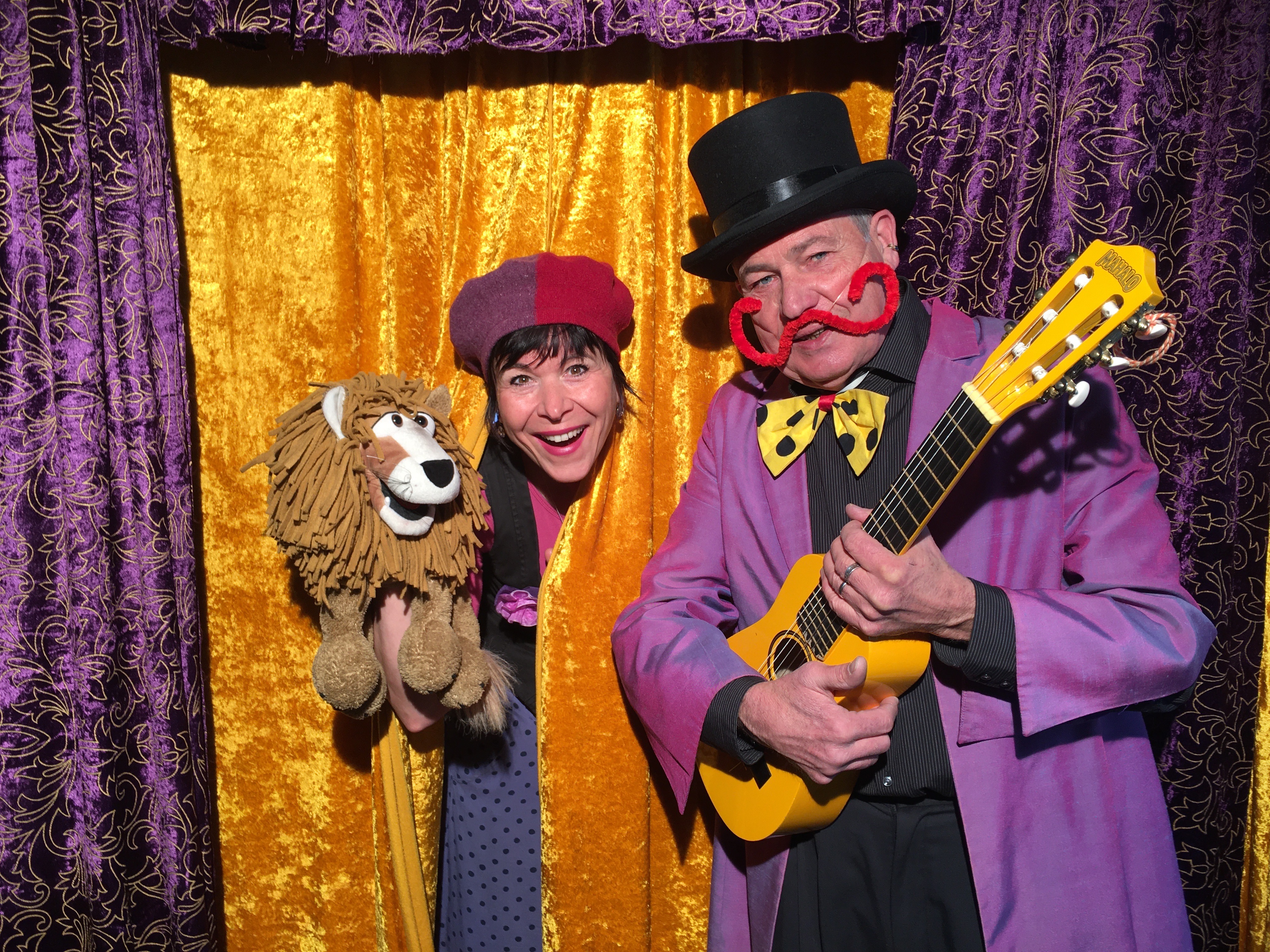 Ein Mann und eine Frau im Kostüm mit einer Löwen-Handpuppe.