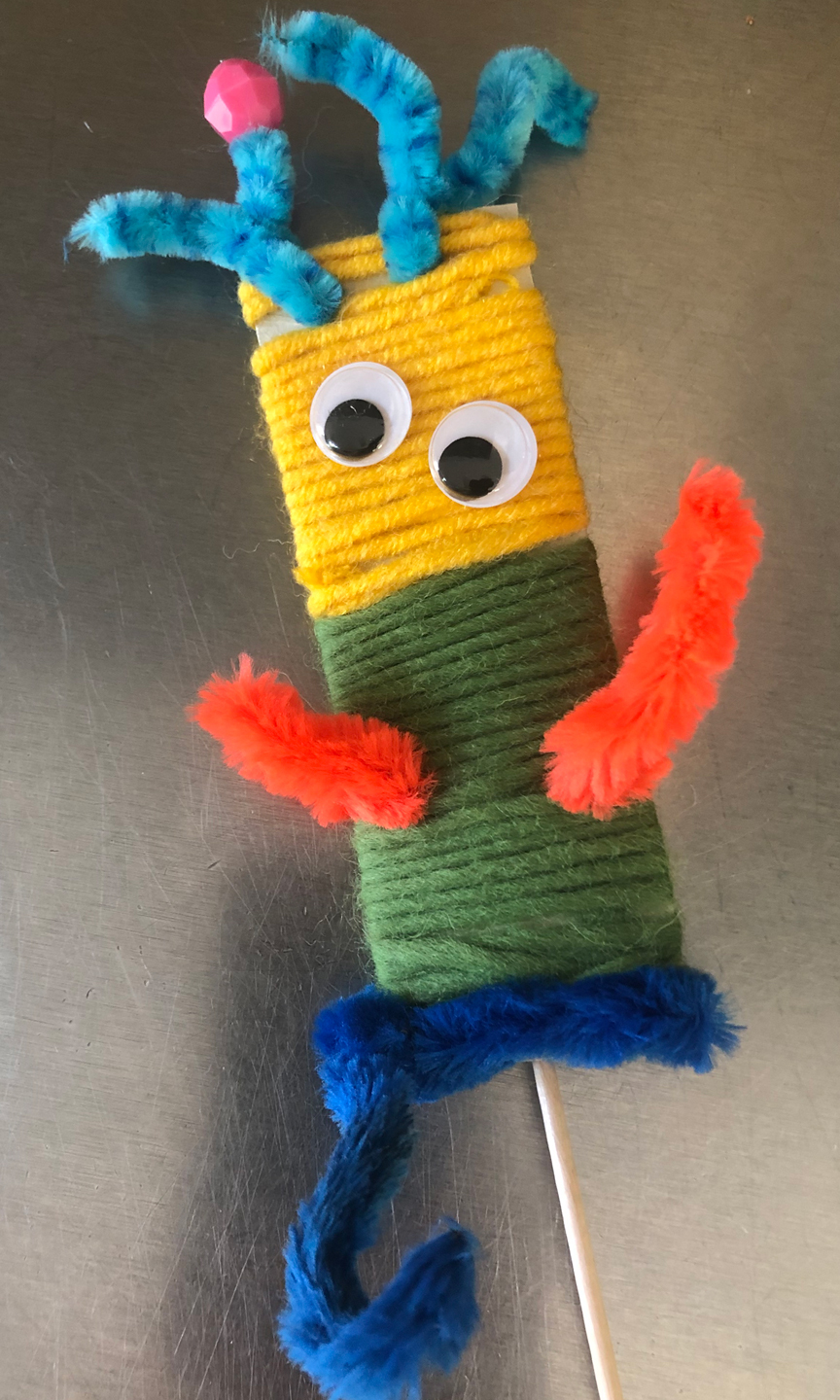 Kleine bunte Wollfigur mit Antennen und einem Schwanz