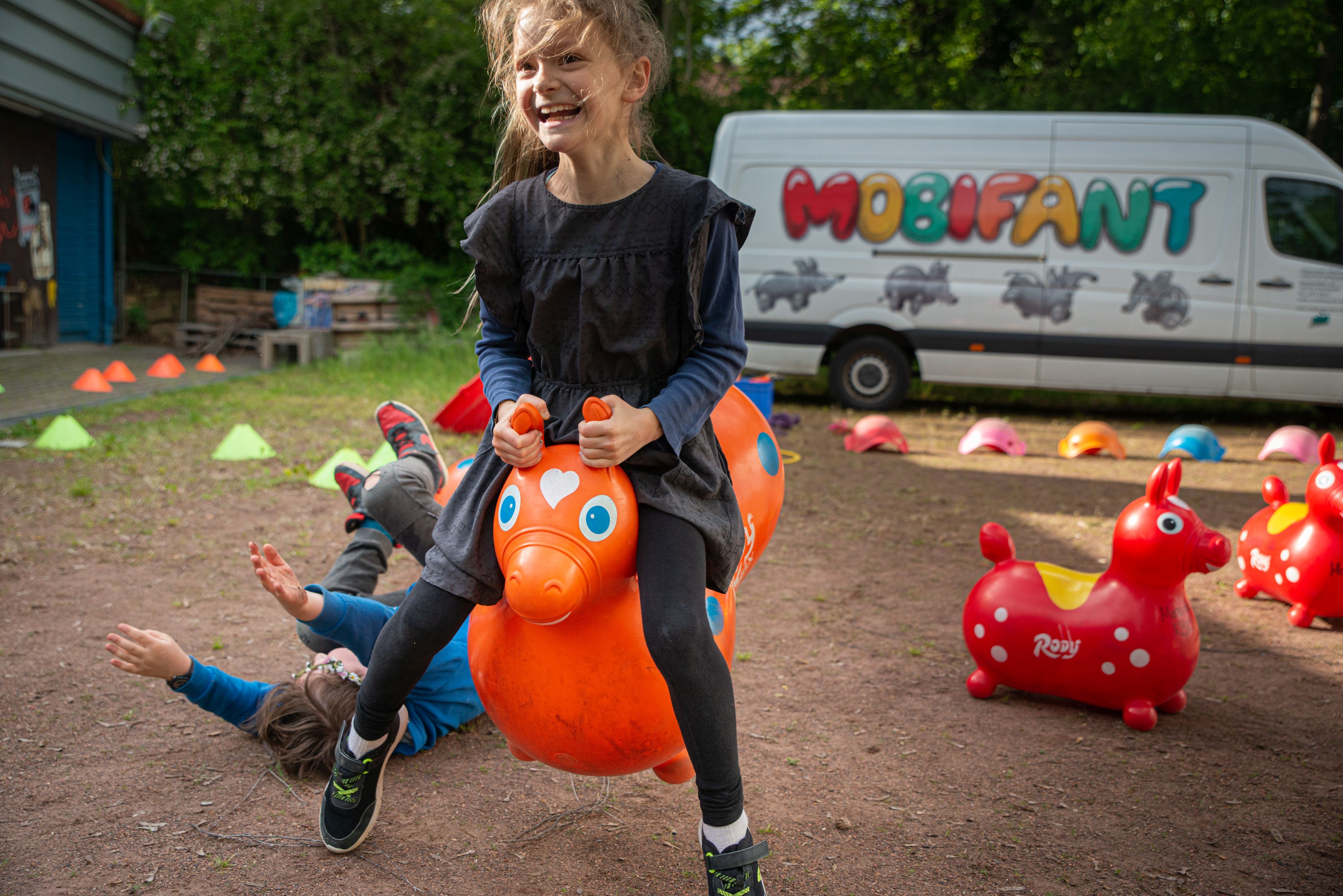 Mädchen hüpft auf einem Gumminilpferd