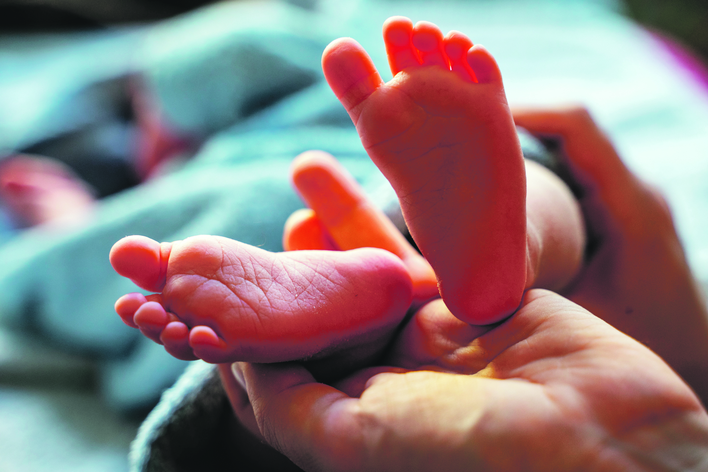 Babyfüße auf einer Erwachsenenhand