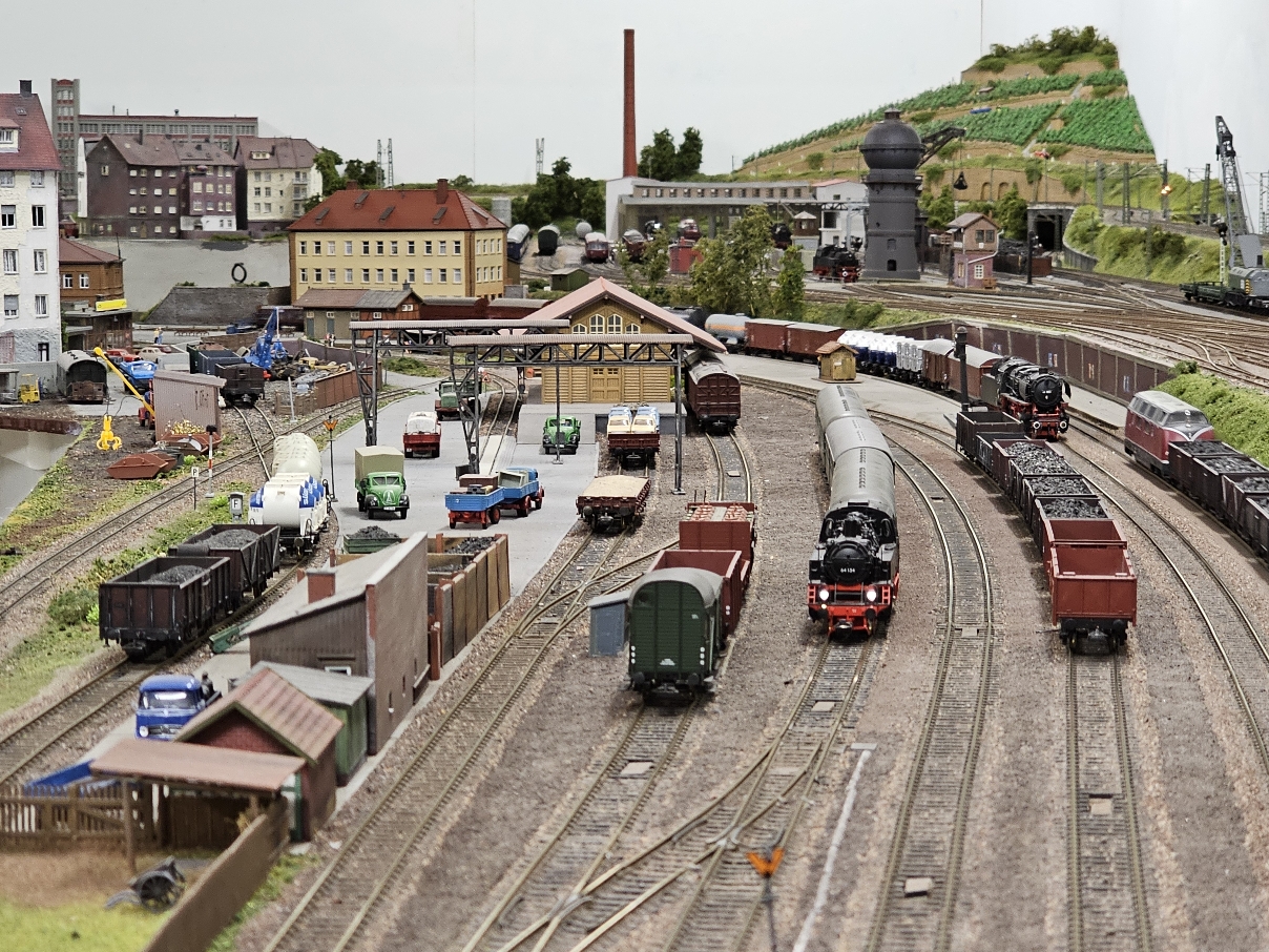 Ansicht auf eine Modelleisenbahn-Anlage mit Modell-Stadt im Hintergrund.