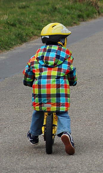 Ein Kind auf dem Laufrad.