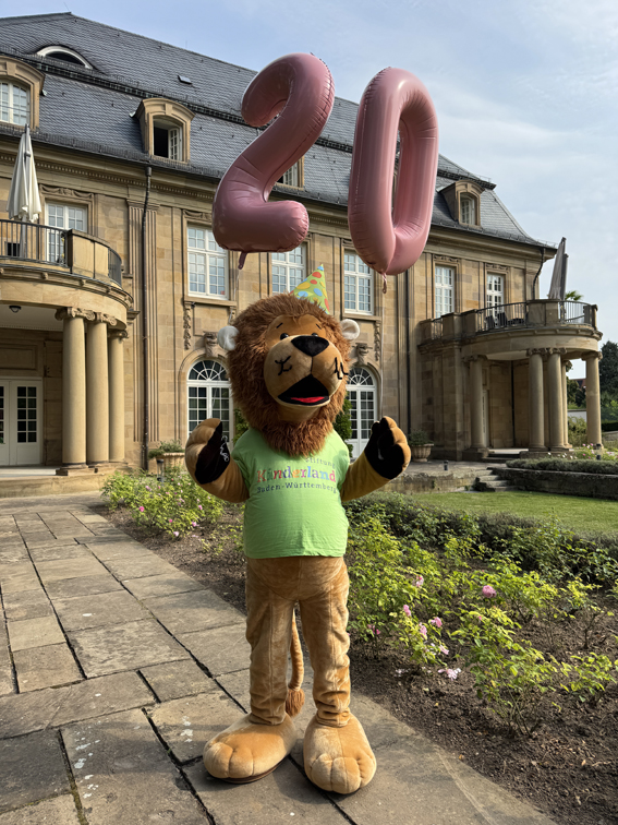 Maskottchen in Form eines Löwen steht vor der Villa Reitzenstein.