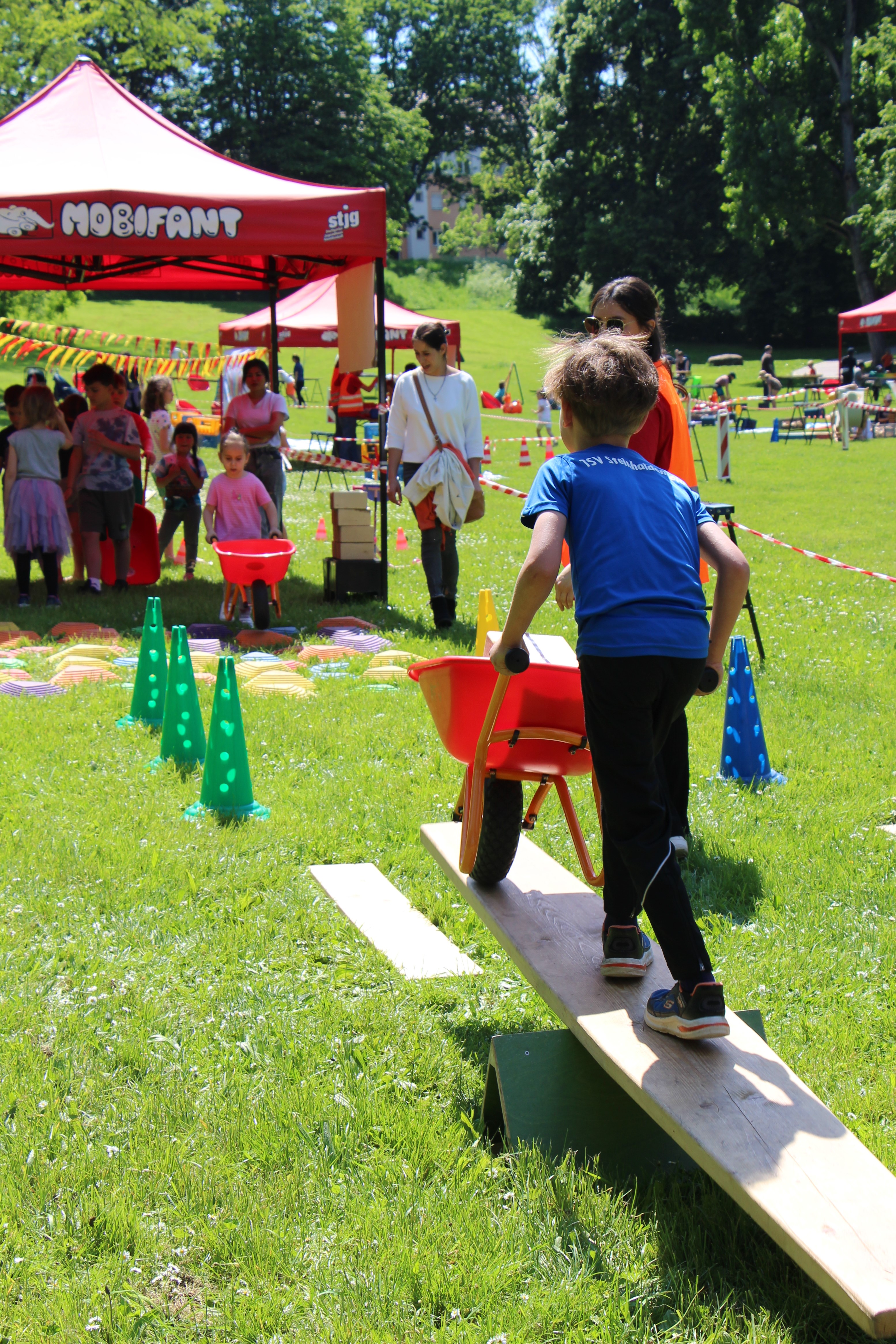Spielstation mit Schubkarren auf einer Wiese.