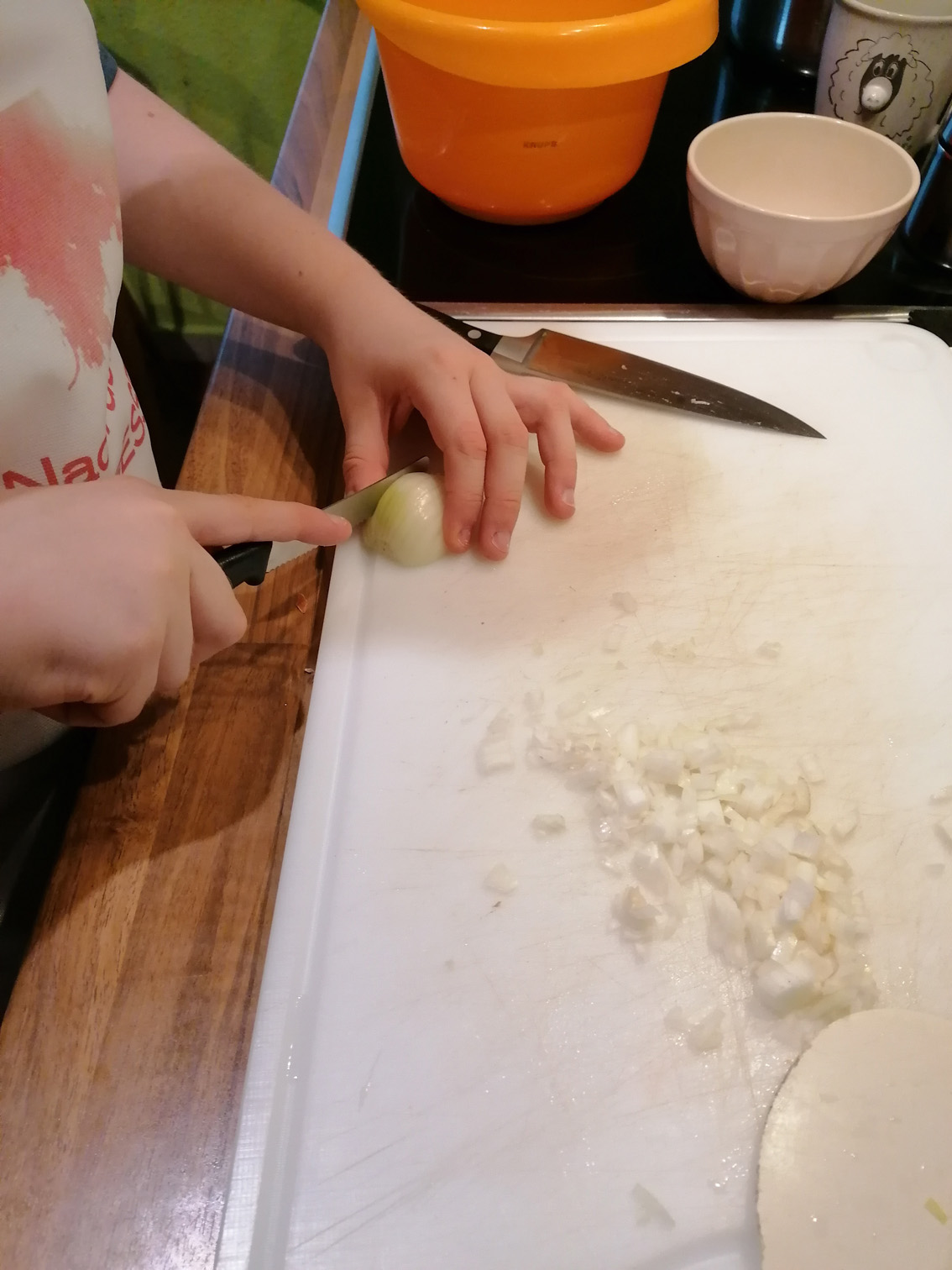 Hände beim Zwiebelschneiden