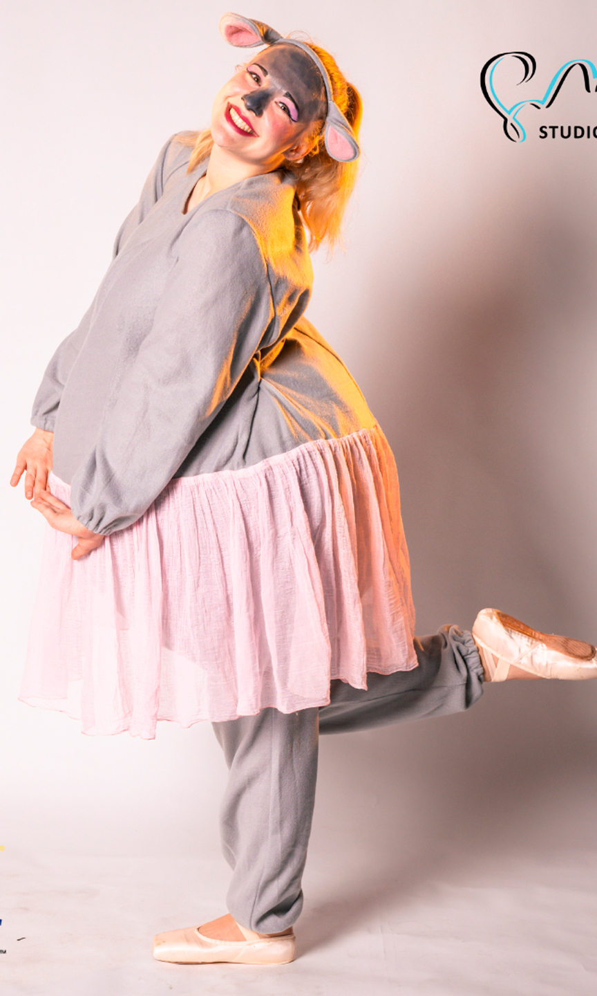 Schauspielerin steht auf einem Bein und lächelt in die Kamera. Sie ist als Nilpferd verkleidet.