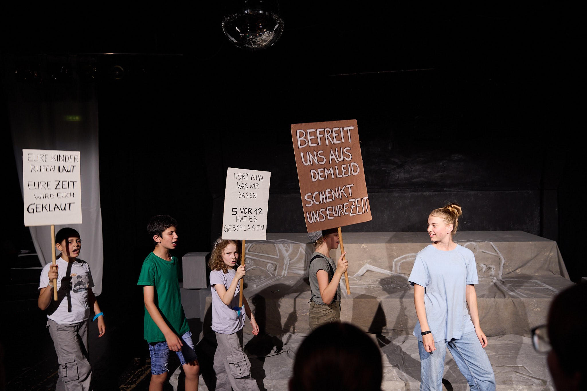 Kinder demonstrieren mit Schildern während der Momo Aufführung