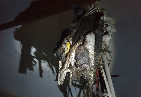 Man sieht eine Kunstinstallation im dunklen, welche nur mit einer Taschenlampe beleuchtet wird.