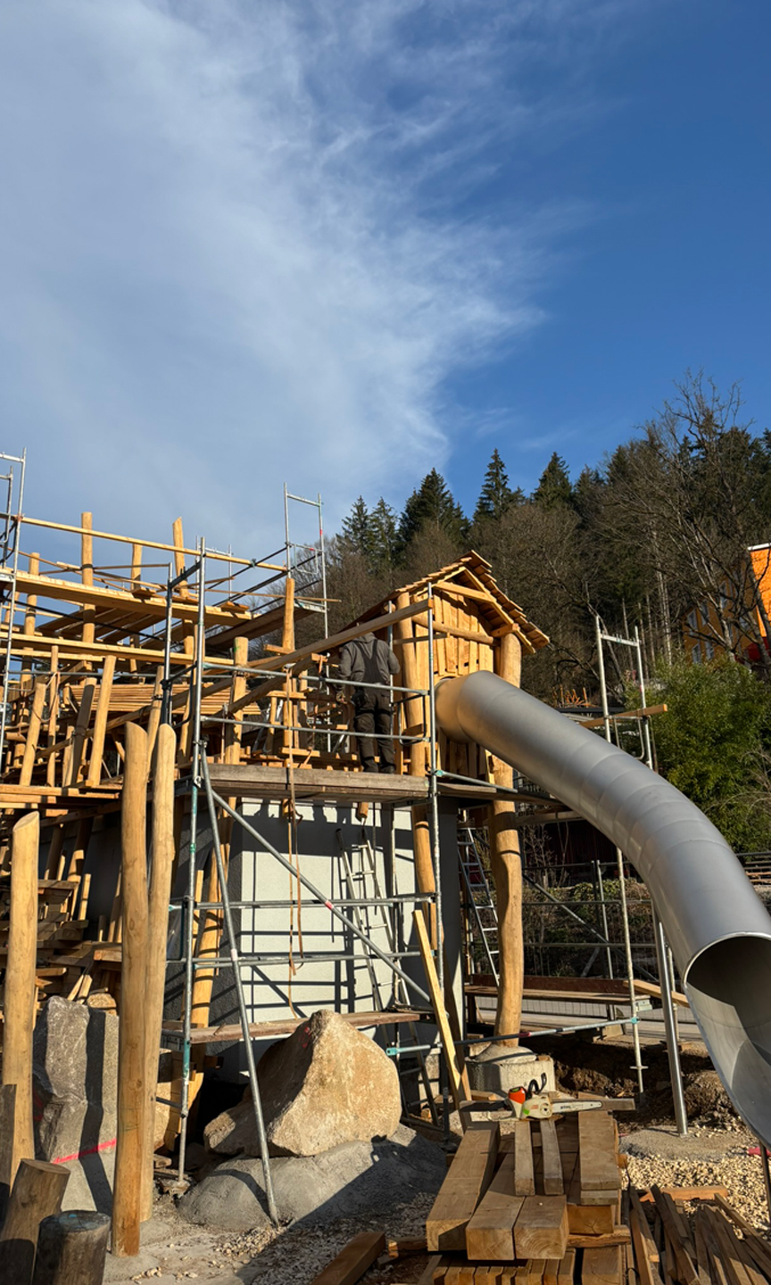 Spielturm aus Holz im Bau. Turm ist eingerüstet.