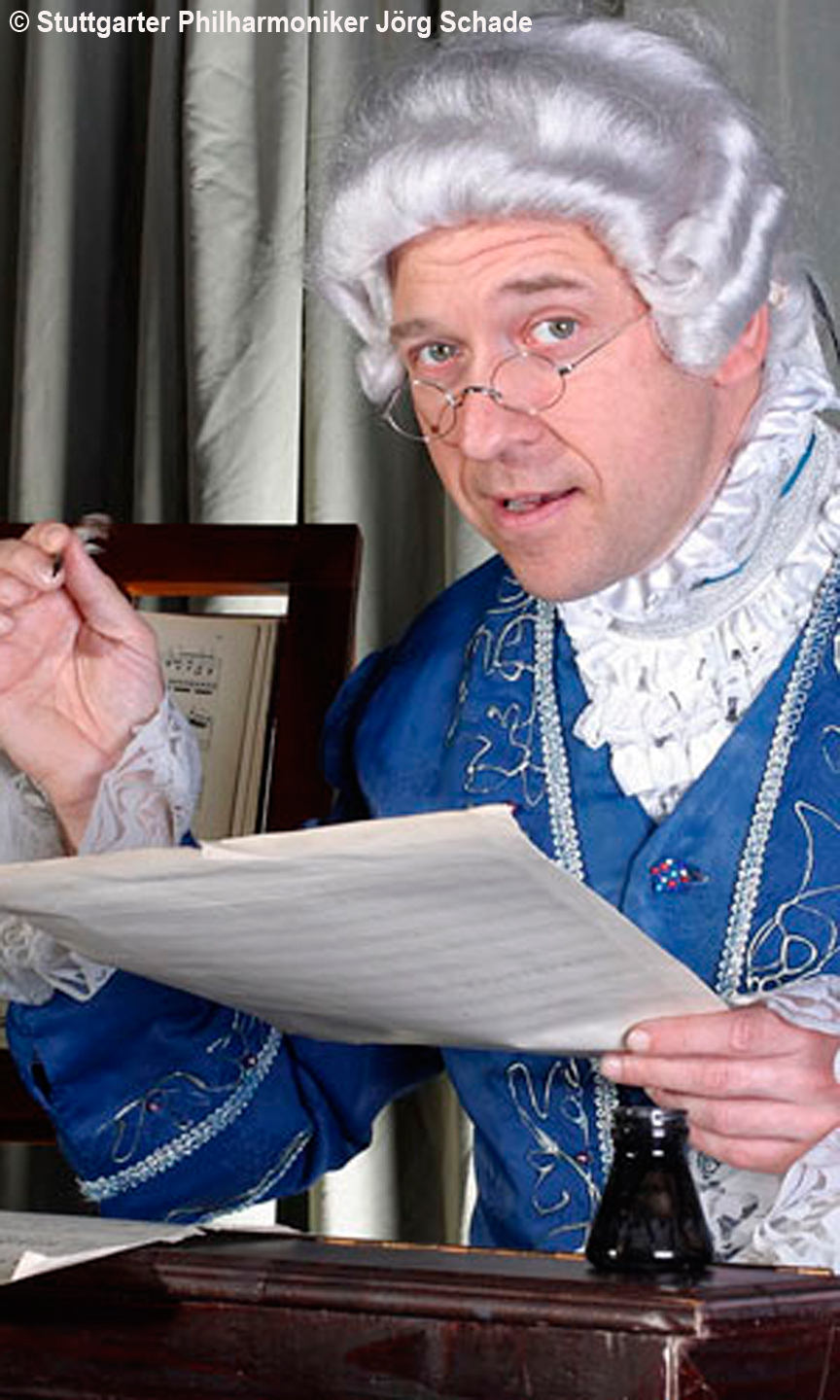 Mann ist als Beethoven mit weißer Perücke verkleidet und hält ein Notenblatt in den Händen.