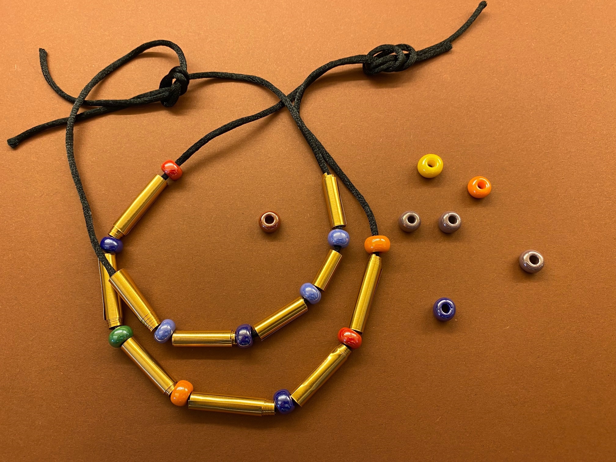 Zwei selbstgebastelte Ketten aus Schnur und bunten Perlen