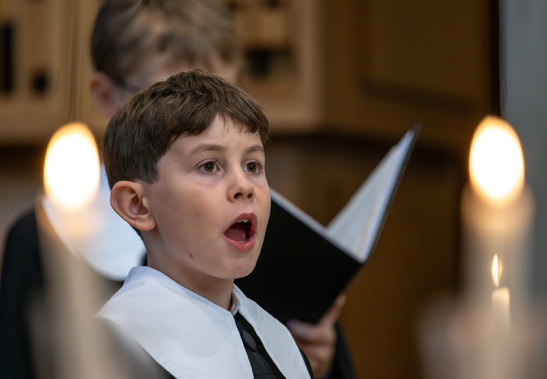 Detailaufnahme eines singenden Jungen in einem Knabenchor.